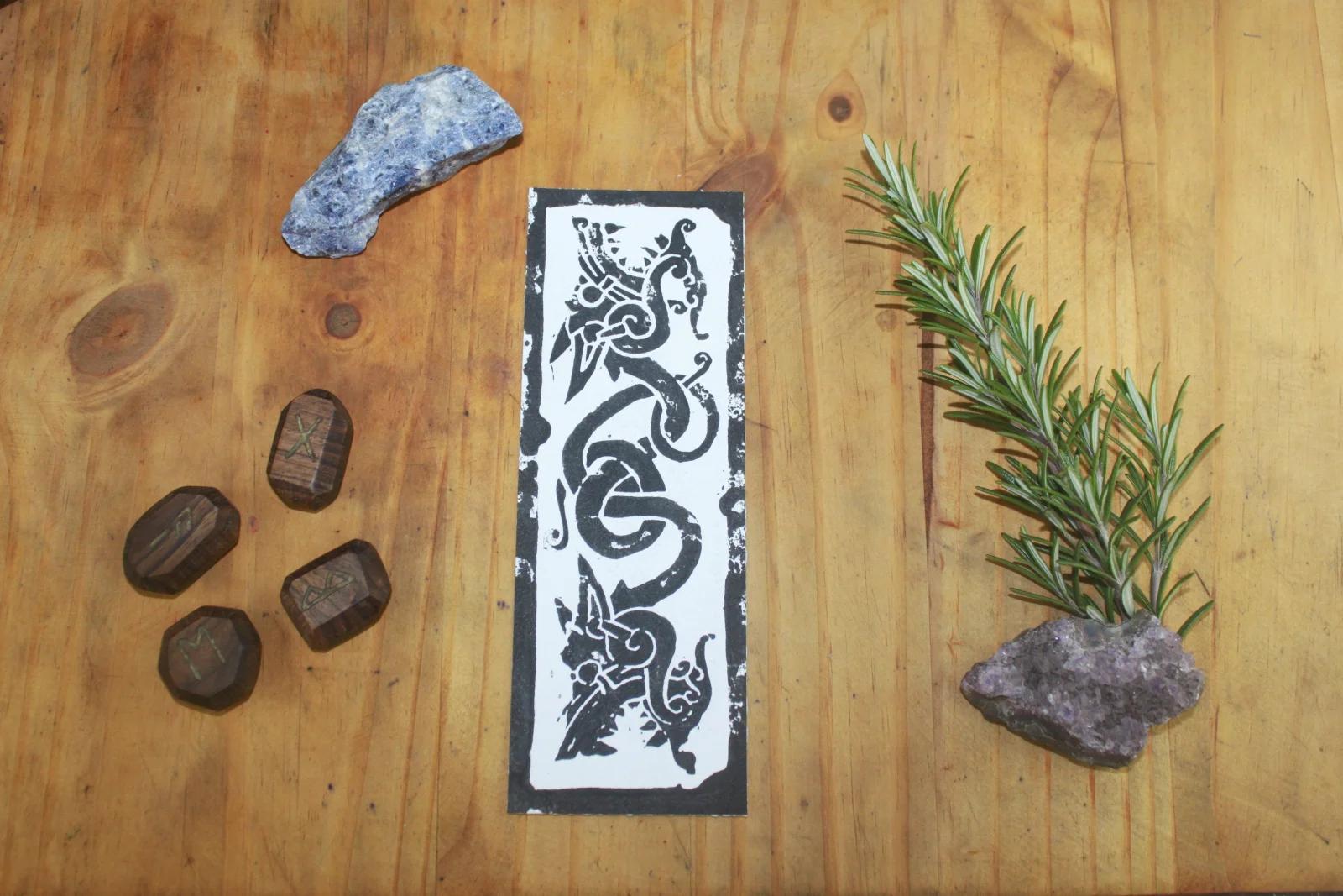 marque page linogravé, artisanal, de fenrir ici dans ça V1 , mythologie nordique , paganisme , sur fond bois avec divers accessoires autour